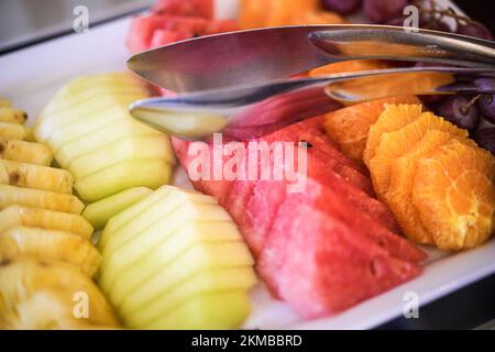 Sliced fruit mix on a plate, orange, watermelon, grape. Stock Photo