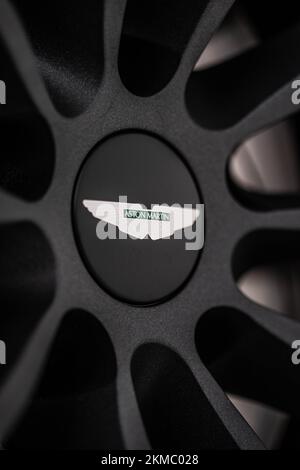 A vertical closeup of an Aston Martin Vantage black wheel with the logo facing upwards Stock Photo