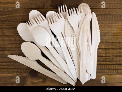 eco friendly disposable kitchen utensils on wooden background. wooden fork, spoon and knife. Ecology, zero waste concept. Top view. Flat lay. Stock Photo