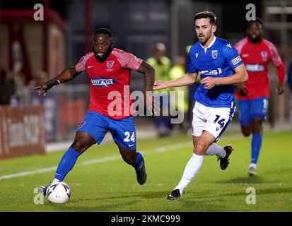 Dagenham and Redbridge's Junior Morias (left) and Gillingham's Robbie McKenzie battle for the ball during the Emirates FA Cup second round match at the Chigwell Construction Stadium, Dagenham. Picture date: Saturday November 26, 2022. Stock Photo