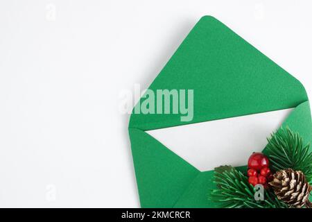 Green envelope with white sheet and Christmas branch isolated on white background. Christmas mail. Concept of congratulation for Christmas or New Year Stock Photo