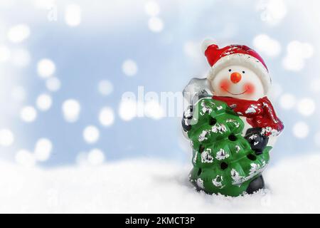 Happy snowman standing in winter christmas landscape. Merry christmas and happy new year greeting card. Funny snowman in hat on snowy background. Copy Stock Photo