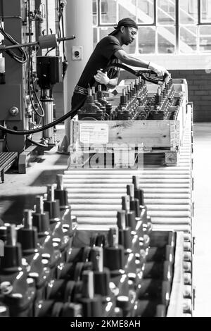A closeup of a male worker in Industrial Valve Manufacturing and Assembly Factory Facility Stock Photo