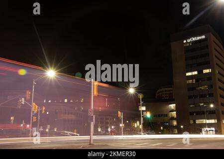 A large uOttawa, University of Ottawa building is seen at night as traffic, light trails pass by in downtown Ottawa. Stock Photo