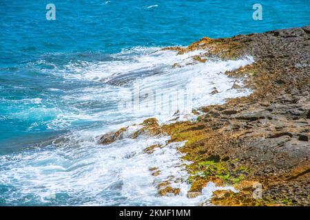 Small waves break on the rocks on the coast Stock Photo