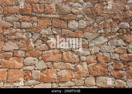 The wall of oval cobblestone color red and orange color, background texture Stock Photo