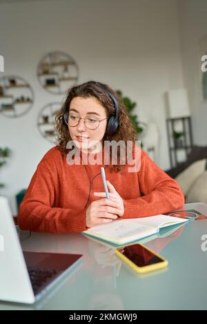 Young woman student elearning or having remote virtual meeting at home. Stock Photo