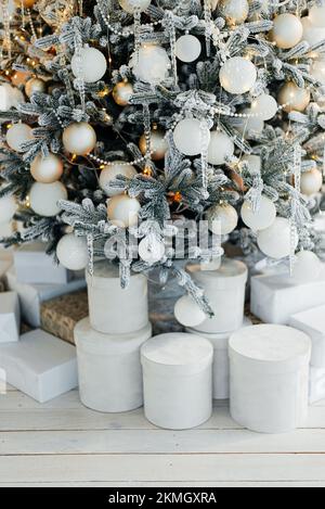 Pile of gift boxes near beautiful Christmas tree indoors Stock Photo