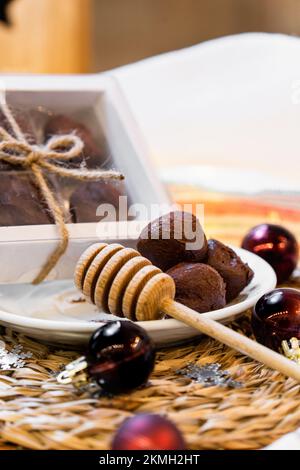 Honey truffles over wood, box and plate with Christmas decorations Stock Photo