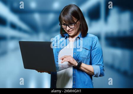Portrait of woman manager worker using laptop in warehouse transporting Stock Photo