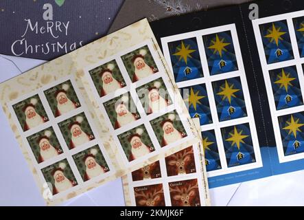 Canada Post Christmas themed postage stamps are pictured on top of cards and envelopes in Victoria, British Columbia The two top blocks of stamps are Stock Photo
