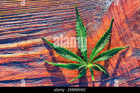 Medical cannabis on a wooden background. Hemp. A wonderful green leaf. Stock Photo
