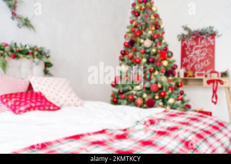 Blurred Christmas background. Christmas themed decorated room with bad and Christmas tree. Stock Photo