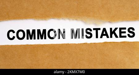 Education concept. There is a gap in the middle of the craft paper, inside of which there is an inscription on a white background - Common Mistakes Stock Photo