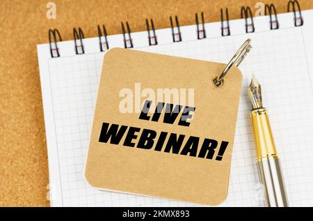 Business and economy concept. There are two notebooks and a pen on the table. On the top notepad, the inscription - Live Webinar Stock Photo