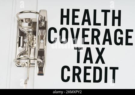 Finance and economics concept. In the folder under a paper clip there is a white sheet with the inscription - Health Coverage tax credit Stock Photo