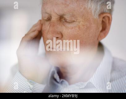 Feeling a little under the weather. an old man looking worried with his eyes closed. Stock Photo