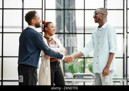 business partners shaking hands standing in the office. Stock Photo