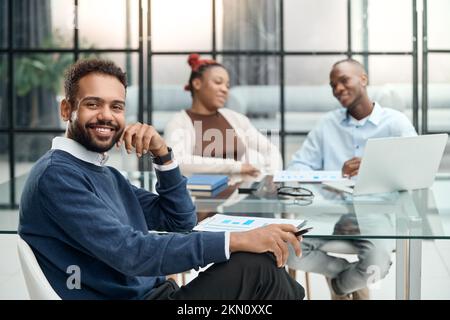 smiling businessman sitting near the office desk. Stock Photo