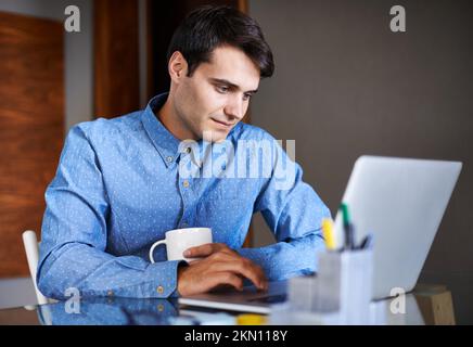 Dedicated to the growth of his new business. a young businessman using his laptop at his desk. Stock Photo