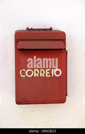 A Portuguese weathered red mail box on a white wall Stock Photo