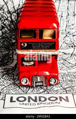 Mapping out an urban scene a red double decker bus routes a map of the Kingdom capital. London Tours Stock Photo