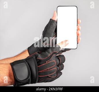 Phone screen mockup for sport application, gym workout app advertisement. Smartphone mock up, blank white display in athlete hand. High quality photo Stock Photo