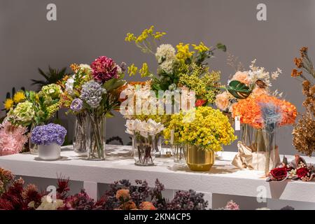 Beautiful showcase of flower shop with large assortment of artificial flowers. Stock Photo