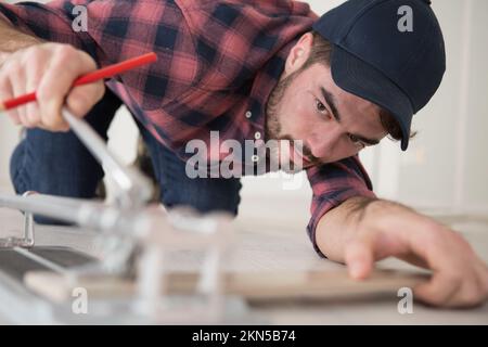 close-up of a man cutting ceramic tiles with handy machine Stock Photo