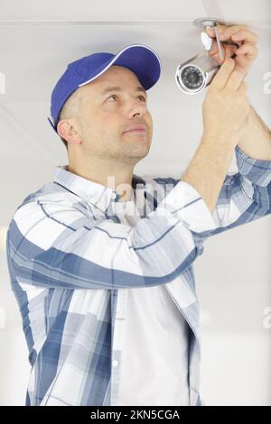 contractor installing surveillance cctv cameras in office Stock Photo