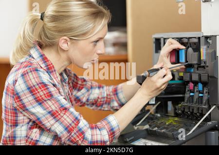 female technician fixing a printer Stock Photo