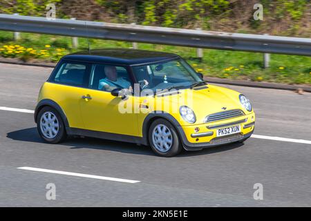 2002 Yellow MINI COOPER 1598cc 5 speed manual; travelling on the M6 motorway, UK Stock Photo