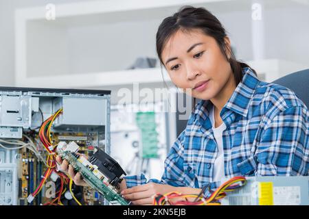 female computer engineer repairing computer motherboard Stock Photo