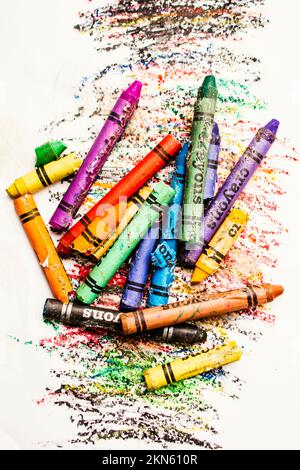 Messy modern art on a heap of old used crayons on sketchy white background. In colours of broken crayons Stock Photo