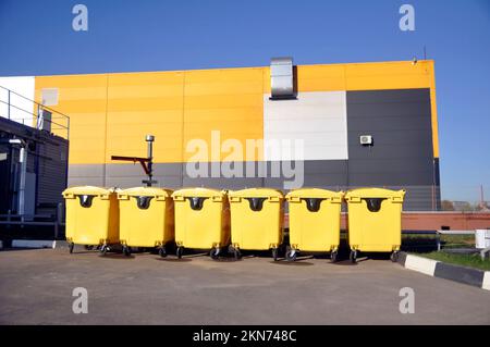 Yellow trash cans on wheels for organized waste collection Stock Photo