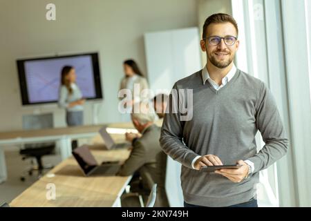 Handsome young modern businessman using digital tablet in the office Stock Photo