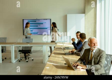 Handsome senior business man working on laptopt in the office Stock Photo