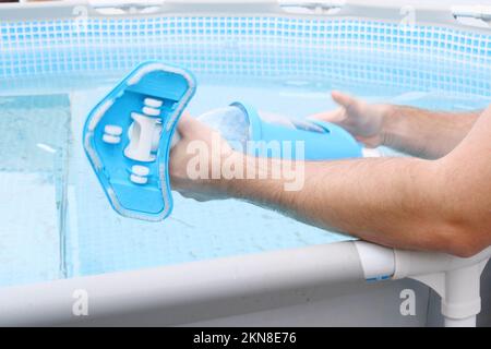 Man assembles a swimming pool vacuum cleaner and service and maintenance of the pool. Stock Photo