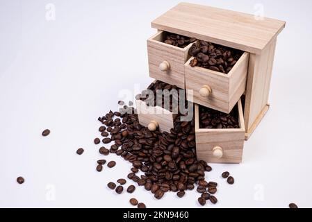 Wooden box with cells filled with coffee beans. Coffee beans scattered side by side Isolated on white background Top view Stock Photo