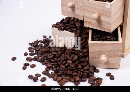 Wooden box with cells filled with coffee beans. Coffee beans scattered side by side Isolated on white background Top view Stock Photo