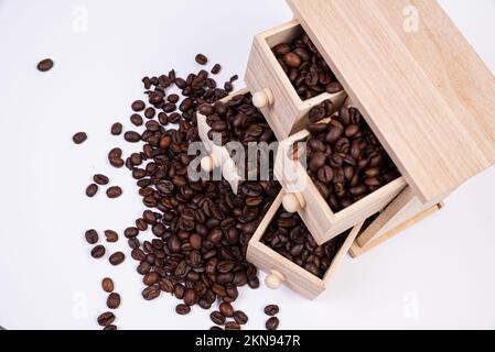 Wooden box with cells filled with coffee beans. Coffee beans scattered side by side Isolated on white background Top view Stock Photo
