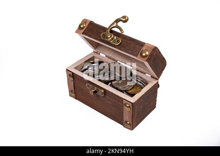 A wooden pirate treasure chest of silver and gold coins isolated on white background. dower chest with old coins coll , front Stock Photo