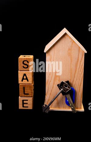 wooden house mockup with house keys, wooden cubes with words rent sale , buy and loan. Project for designer on black background Stock Photo