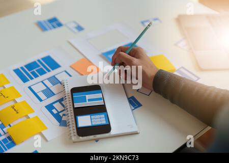 Group of UX UI or designers working to create content of mobile applications. Creative digital development agency concept Stock Photo