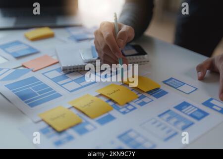 Group of UX UI or designers working to create content of mobile applications. Creative digital development agency concept Stock Photo