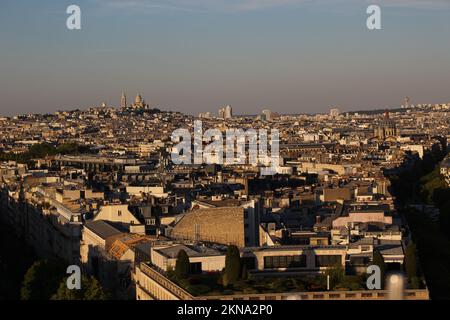 View of Sacre Coeur and Paris from Arc de Triomphe in summer at sundown with visible air pollution on a clear evening (Paris, France). Smoggy skyline Stock Photo