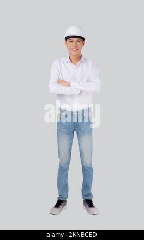 Portrait young asian man is engineer wearing helmet standing and smiling with confident isolated on white background, handsome male is architect or co Stock Photo