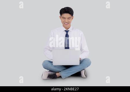 Young asian business man sitting work on laptop computer to internet online isolated on white background, businessman confident and notebook, freelanc Stock Photo