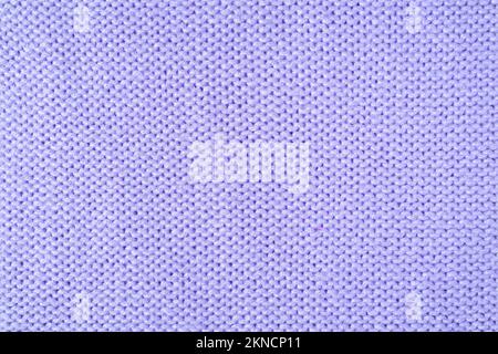 Close up background of knitted wool fabric made of viscose yarn. Pastel purple color wool knitwear texture. Abstract knitted jersey background. Fabric Stock Photo