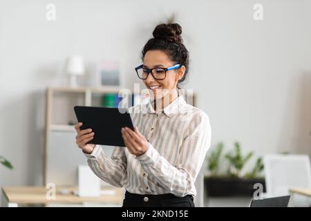 Modern technologies in business. Happy businesswoman using digital tablet in office, getting ready for presentation Stock Photo